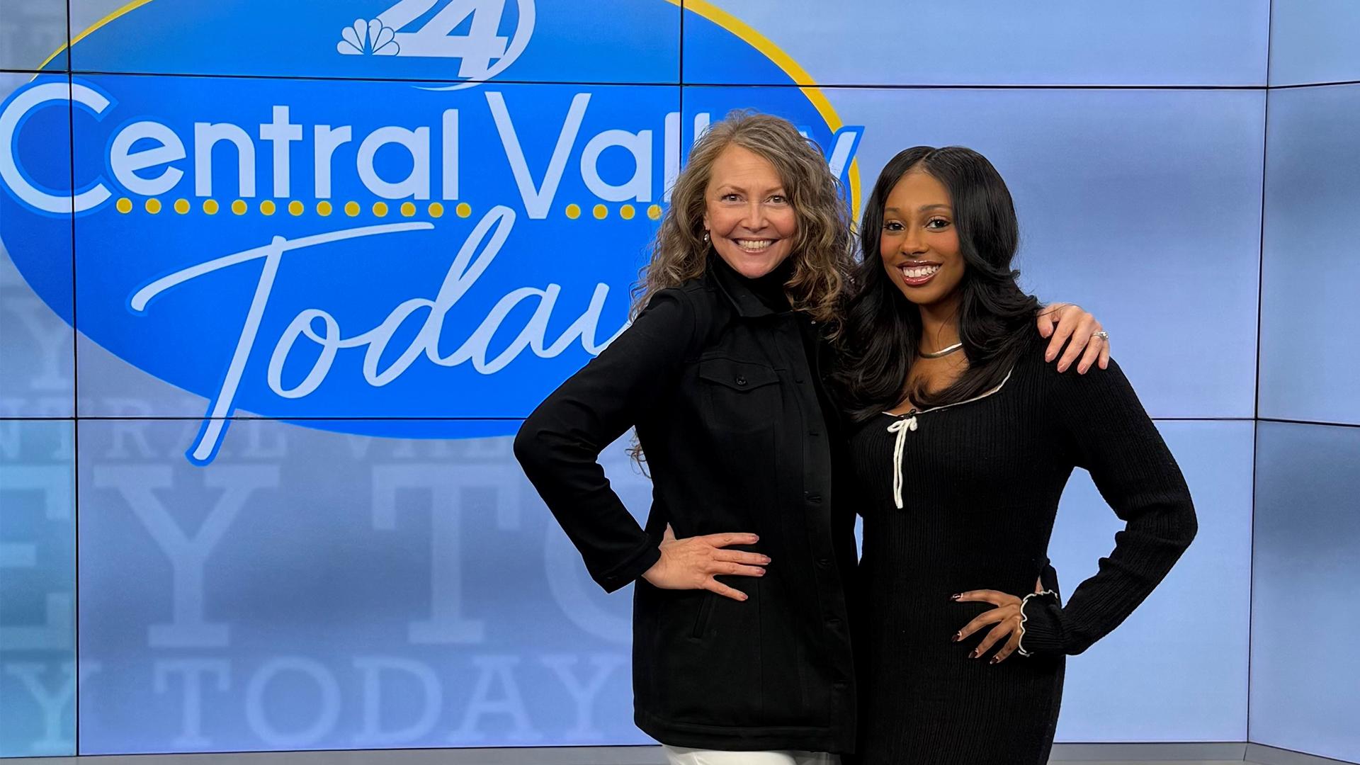 Our guest is standing with the show's host, both smiling.