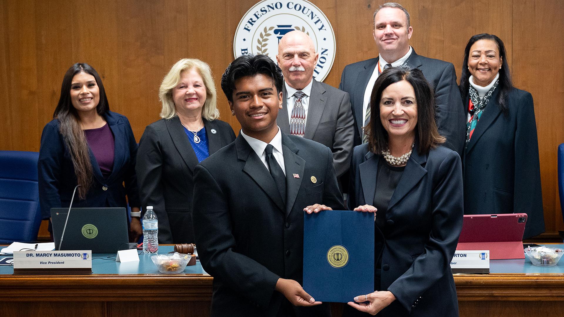 The smiling honoree is holding his certificate surrounded by the Fresno County Board of Education and the Fresno County Superintendent of Schools.