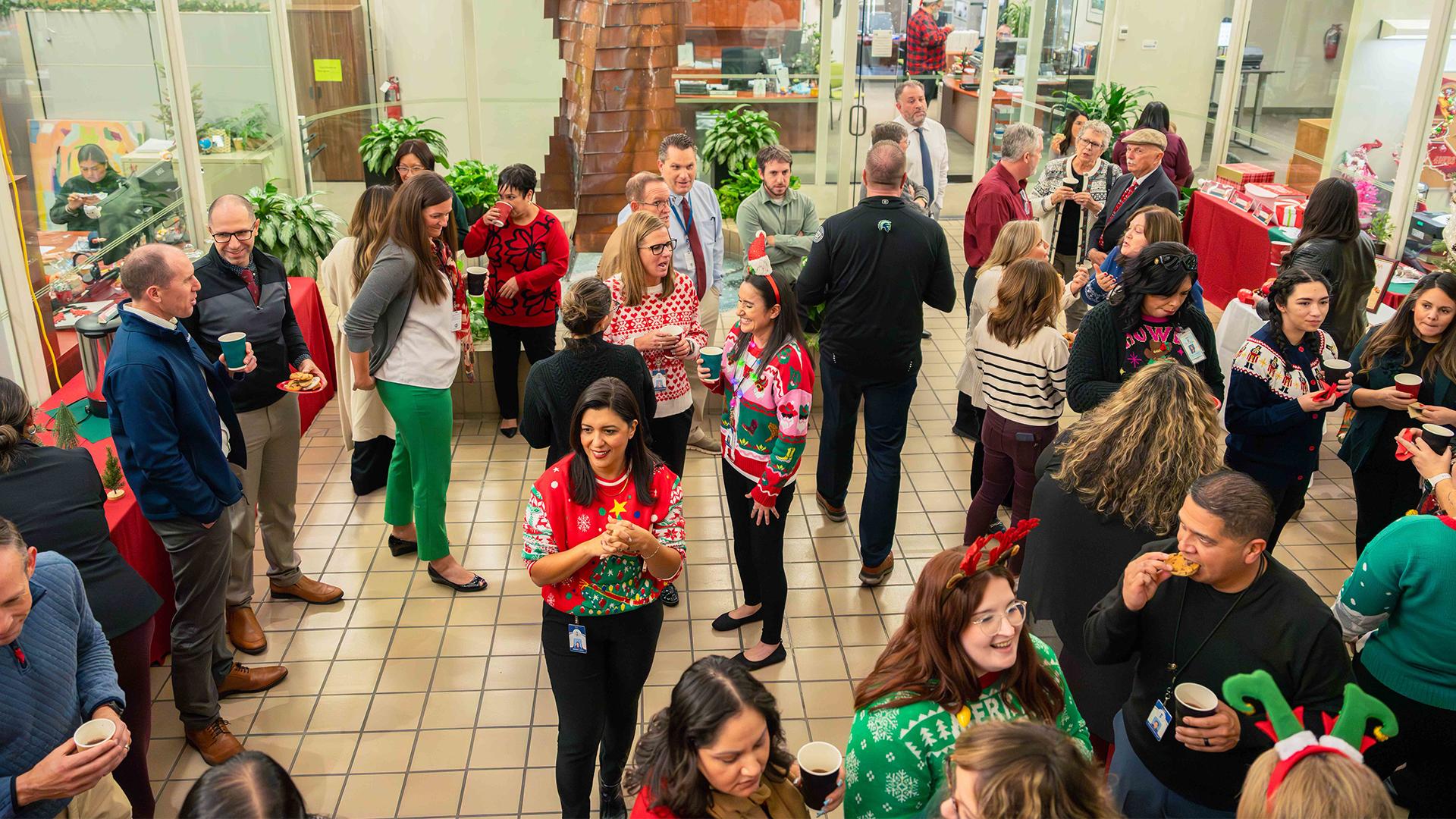 Staff is gathered in the lobby, smiling and visiting, while eating cookies and enjoying beverages.