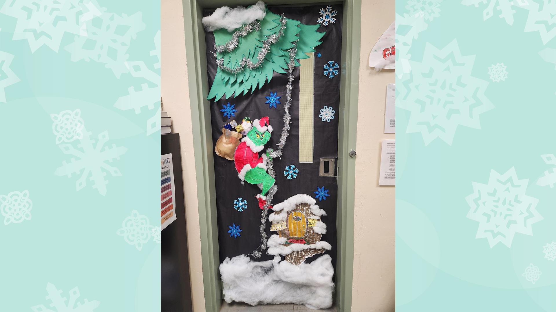 A classroom door is decorated with a Grinch delivering packages to a home in Whoville.