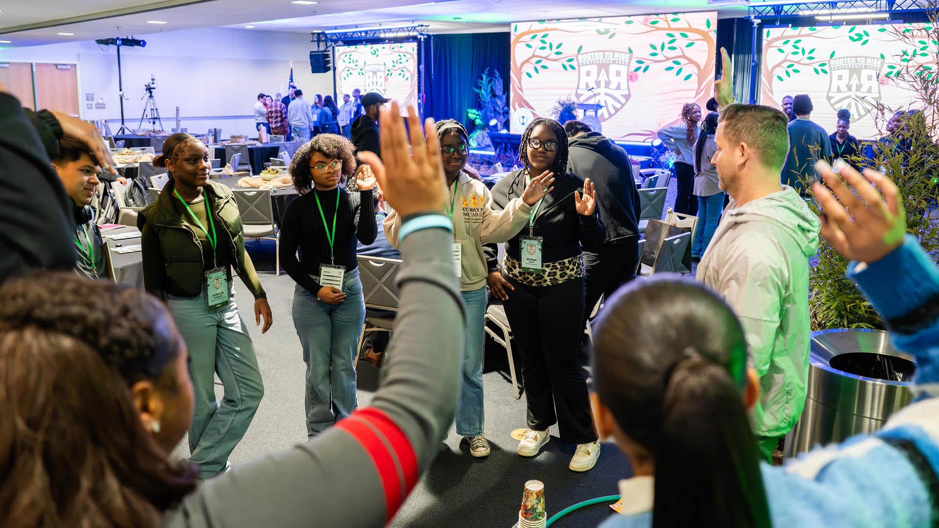 Students are standing in a circle during a breakout session.