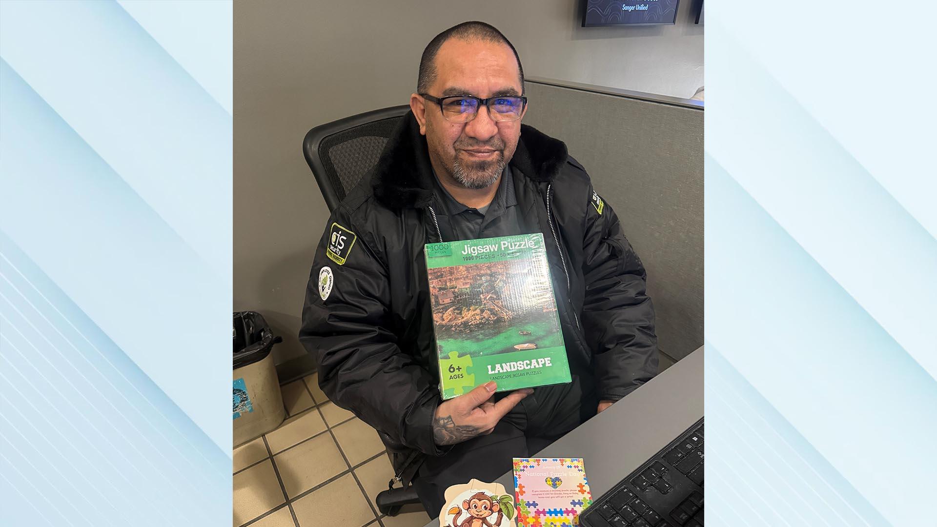 The winner is sitting, holding his puzzle box.