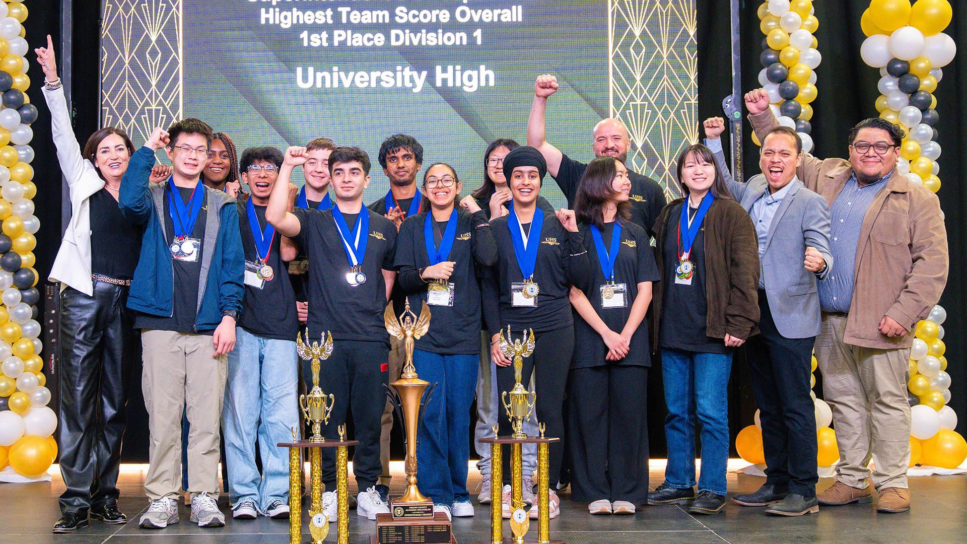 The team is on stage with their award, smiling. 