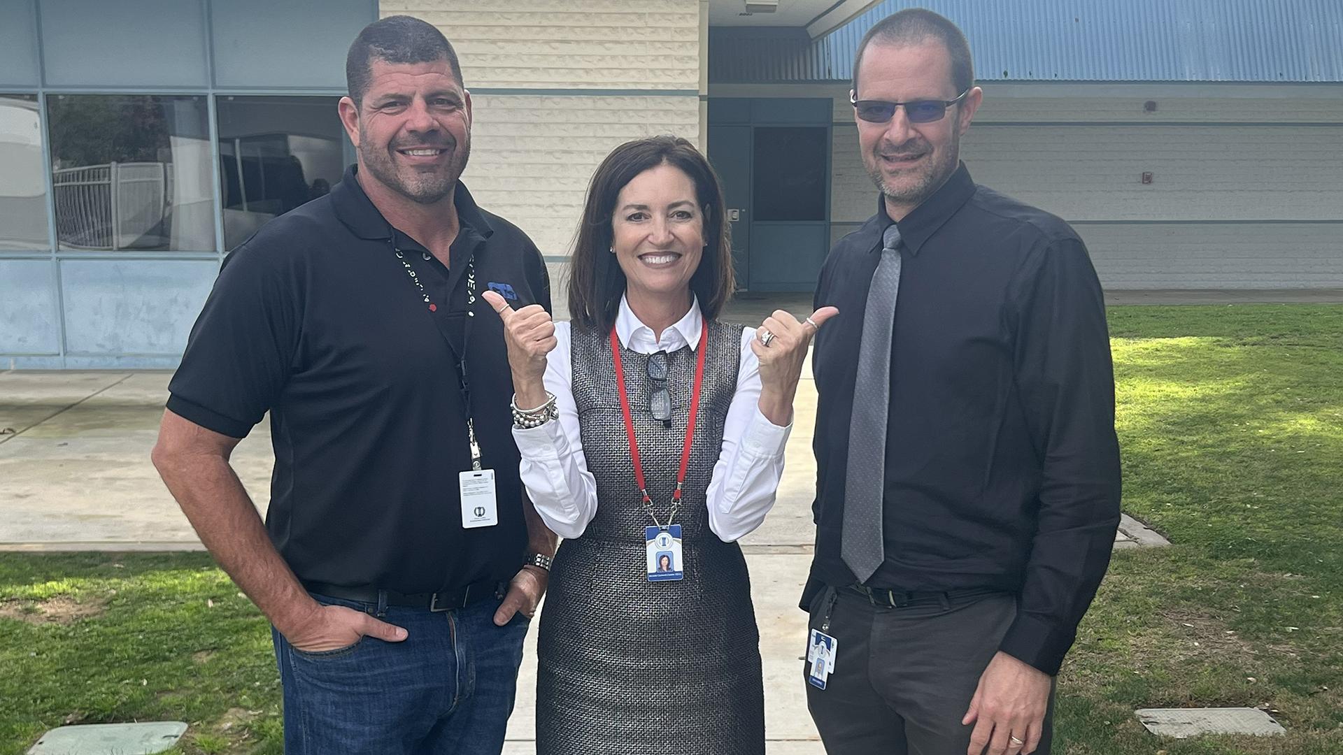 Three people are standing together. 