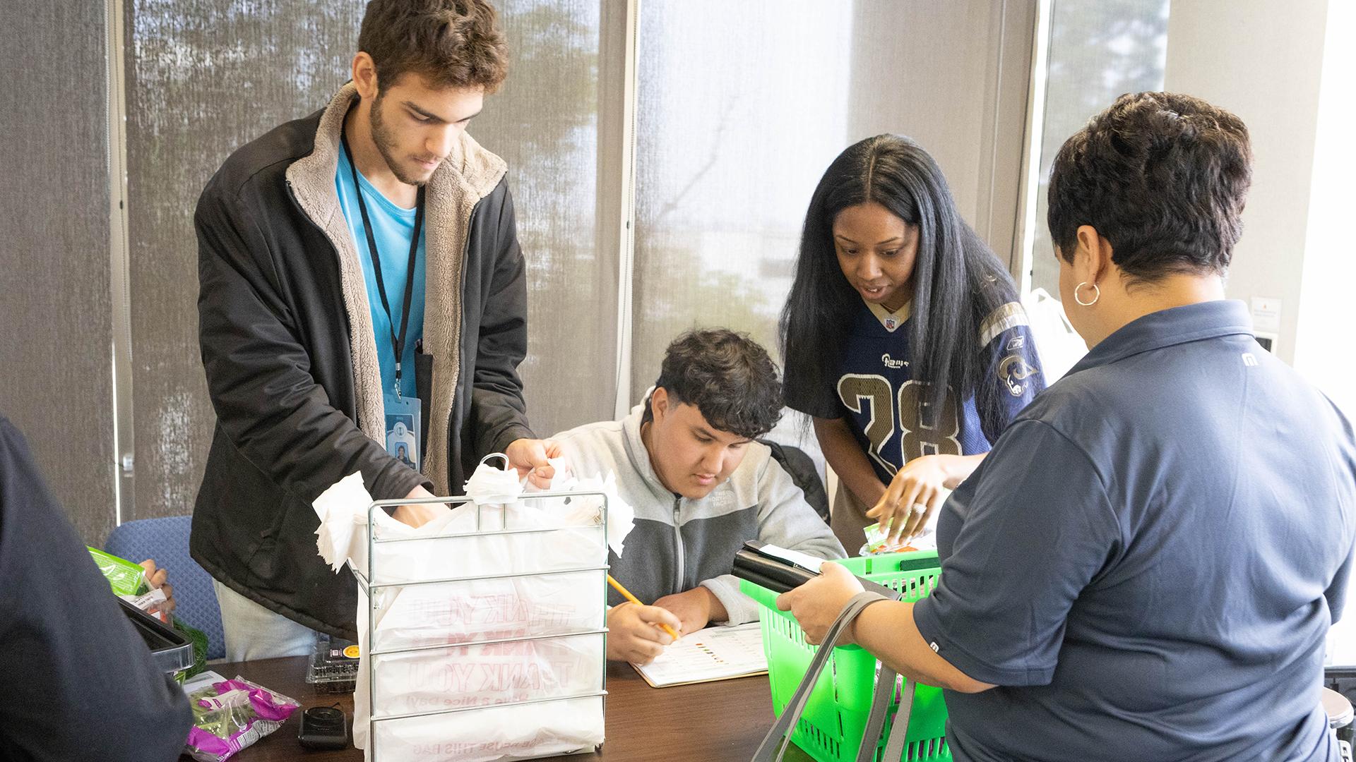 A person is paying for their produce with a student who is sitting at a desk.  