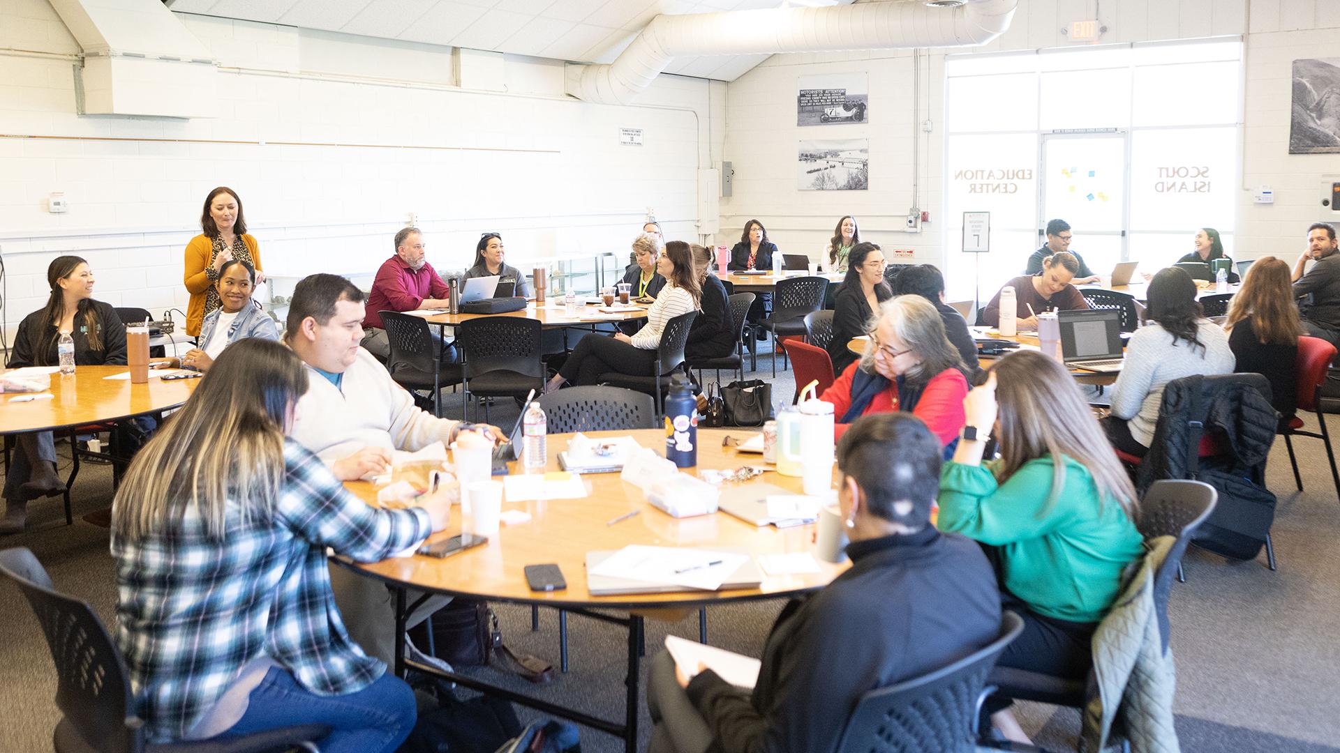 People are sitting at round tables. 