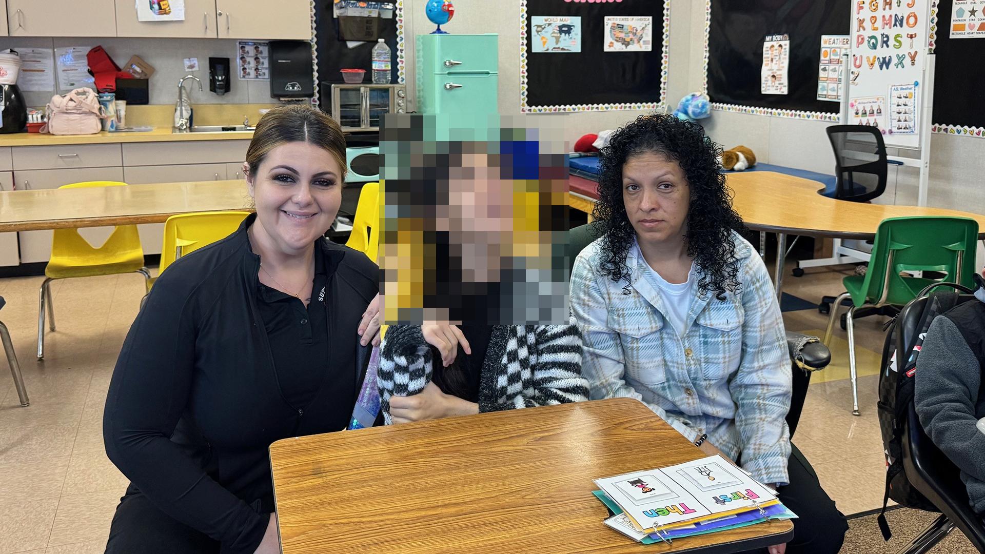 Two staff with a student are seated at a table. 