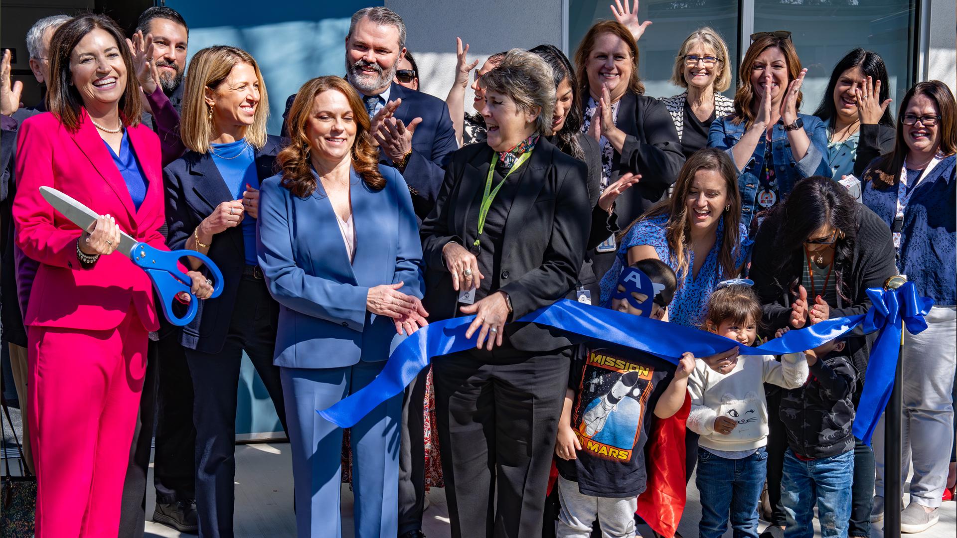 A group of people are cutting the ribbon. 