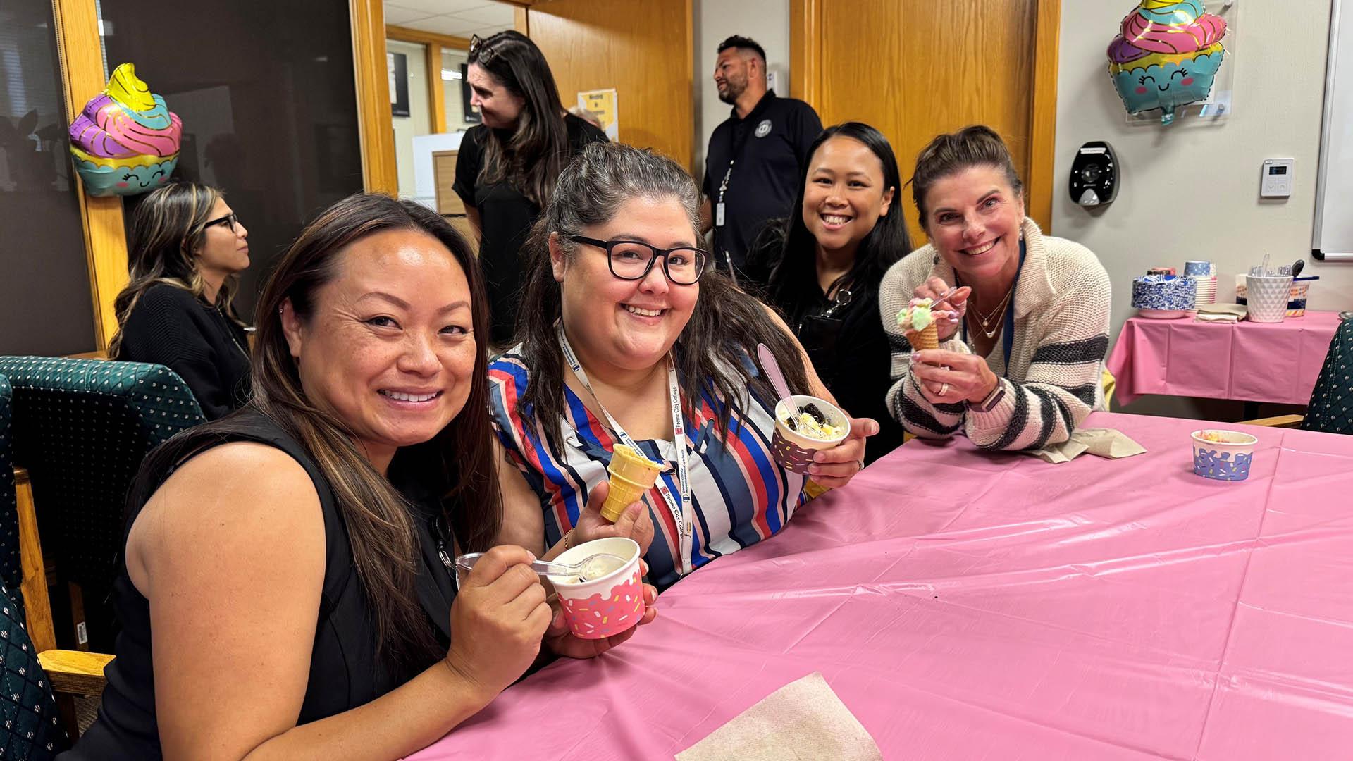 People sit at a table together, enjoying ice cream. 