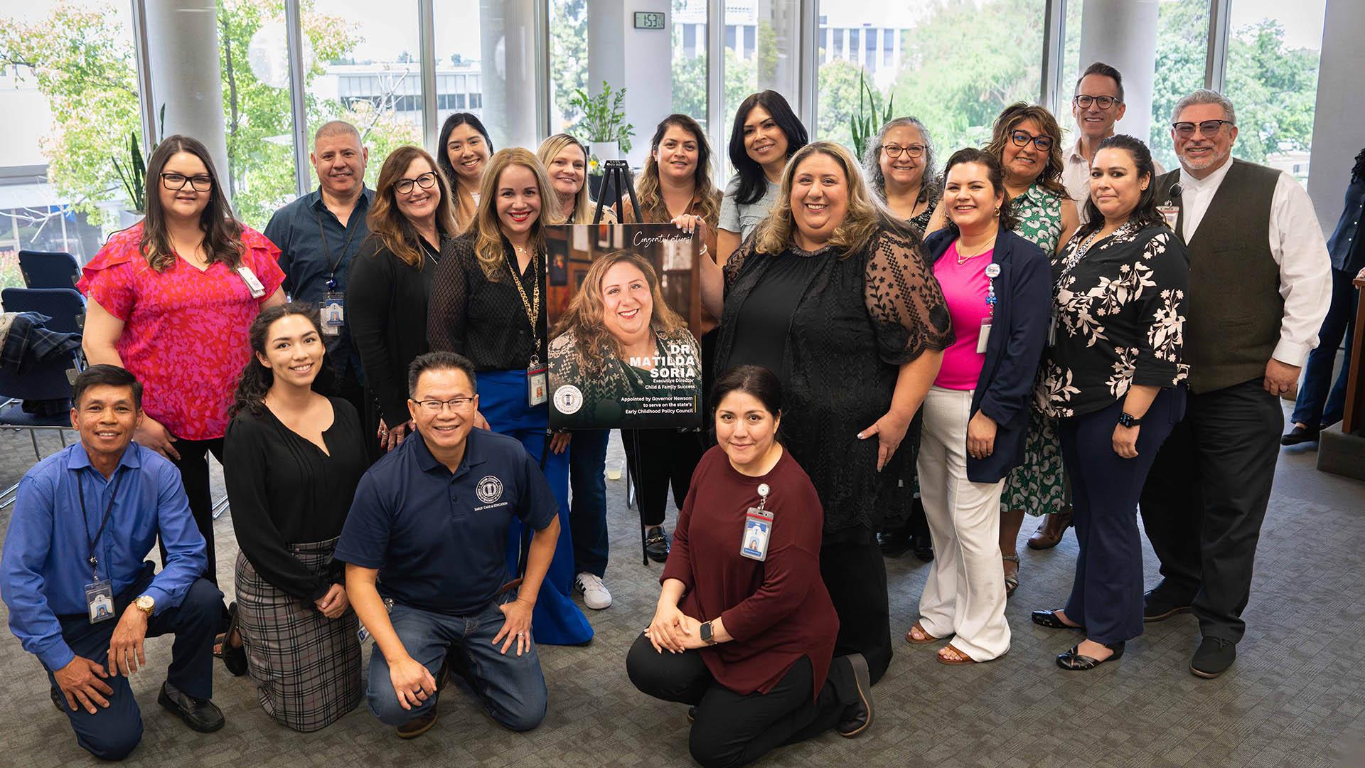 A large group of staff members stand together to celebrate Dr. Soria. 