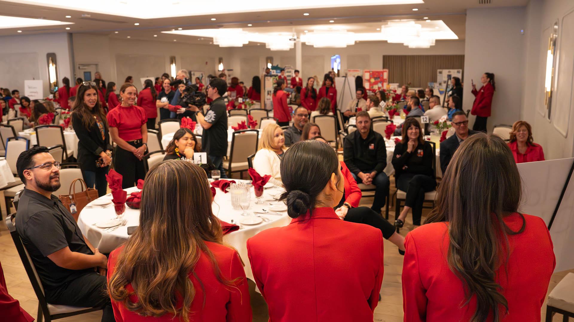 Students talk with guests at a luncheon. 