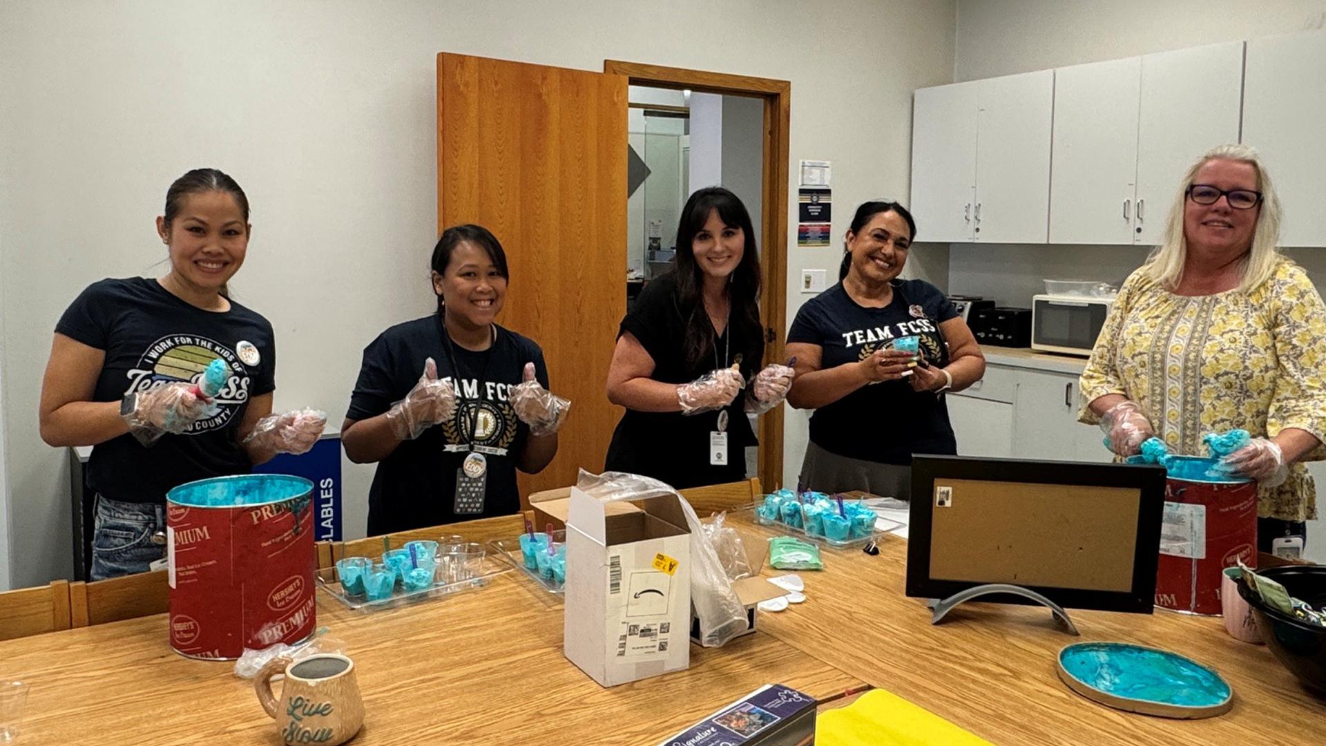 Five coworkers are about to enjoy their ice cream.
