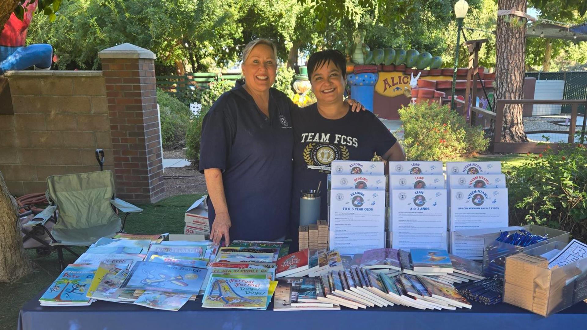 Team members pose for a shot next to a table full of resources.