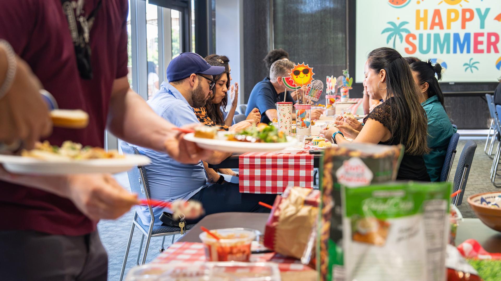 FCSS staffers enjoy that last Summer Potluck at a table.