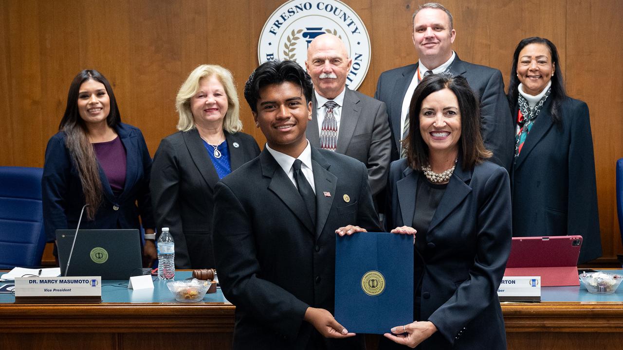 The smiling honoree is holding his certificate surrounded by the Fresno County Board of Education and the Fresno County Superintendent of Schools.